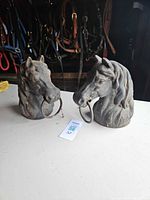 Front view of both cast iron horse head post toppers with rings