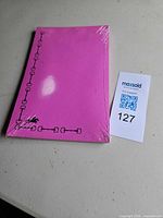 Front view of sealed pink notepad, horse motif visible