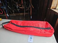 Full view of red bridle bag lying flat showing size and zipper