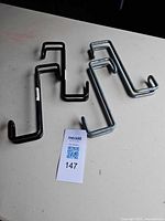 Four over-the-door hooks grouped on table showing two finishes