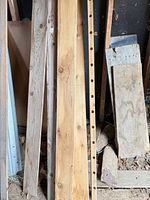 Stack of mixed-width softwood boards showing grain and drilled holes