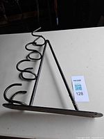 Full view of Stubbs black metal bridle rack showing five hooks and mounting plate