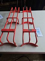 Pair of red Stubbs metal boot racks on table