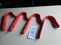 Four red Stubbs bridle hooks laid out