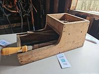 Overall view of wooden toolbox with farrier tools inside