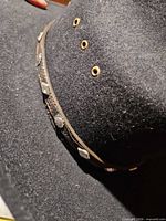 Side view showing decorative hat band and vent grommets