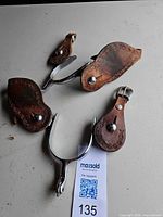 Entire set: two metal spurs and multiple leather straps displayed
