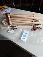 Stack of five wooden neck cradles with tags visible