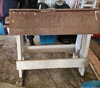 Front view showing white painted legs, brown top plank