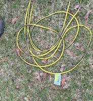 Coiled yellow and black extension cord laid on grass