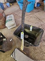 Full view of splitting maul leaning in tub with sunshade nearby