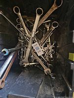 Loose assortment of chrome combination wrenches in bin