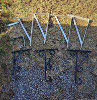Group shot showing all nine brackets: four white triangular, three black scroll, two small corner