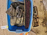 Overview of tote containing boots, broom head, air tool, sockets tray alongside