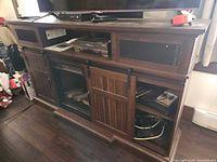 Full view of espresso TV stand with electric fireplace, sliding barn doors, open component shelves