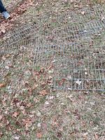 Several galvanized wire grate panels spread on ground