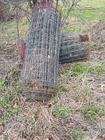 Two rolls of galvanized welded wire fence resting on ground