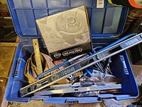 Open tote showing 48-in level, tool belt, brake rotor box, assorted tools