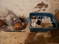 Overall view showing sled with potted flowers, wire basket, and blue tote containing lantern, snowflake lights, fabric pieces