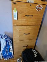 Front view of tall 4-drawer light oak filing cabinet with black handles