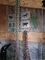 Both galvanized and rusted chains hanging on wall