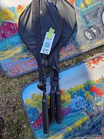 Two badminton racquets in black cover placed on top of two identical farm-theme welcome mats