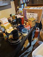 Assorted household items on table including Yankee Candle jars