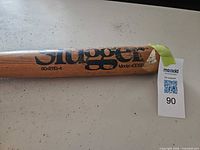 Close-up of Louisville Slugger logo and model markings on barrel