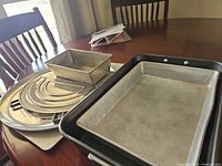 Stack of loaf pan, pizza pans, sheet pan, roasting pan