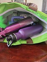 Open green lunch bag showing multiple bottles inside