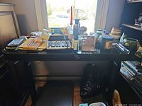 Overview of lot on tabletop showing calculator, glass dishes, tongs, grill brush, jars and candles