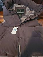 Front view of Mountain Horse grey down vest showing zipper, snap placket, collar and hood, brand tag visible