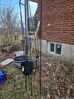 Full view of black metal trellis standing upright outdoors