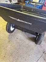 Side view showing Red A Rock logo, pneumatic tire, plastic bed