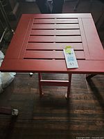 Top view of red plastic folding side table with slatted surface