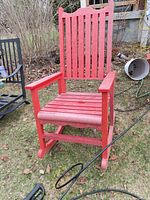 Front view of red recycled plastic rocking chair on lawn