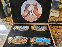 Open display box showing all four knives and interior artwork
