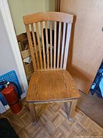 front view of oak dining chair showing slat back and seat