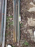 Bundle of steel fence posts lying on ground