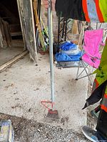 Full view of steel soil tamper showing shaft and head