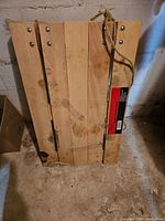 Top view of wood platform dolly showing surface boards, rope handles, and manufacturer label