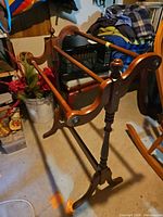 Full side view of wooden quilt rack showing three rails, turned legs, and curved side pieces