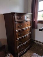 Full view of tall brown five-drawer wooden dresser
