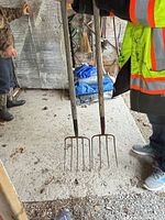 Both garden forks full length view leaning against wall