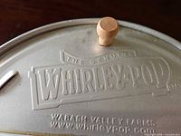 Embossed Whirley-Pop logo and wood knob on lid