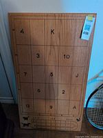 Full view of wooden game board with numbered and lettered grid, animal icons and cribbage scoring track