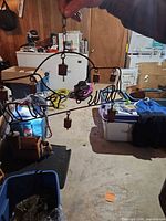 Full view of wrought iron cow outline wind chime with multiple bells and hanging chain, showing rusted patina