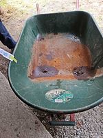 Top view of green plastic tub showing interior rust and capacity sticker