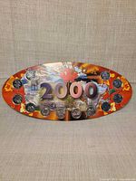 Front of oval card displaying all six mounted coins around large '2000' text