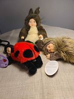 Three Anne Geddes baby dolls laid out on table